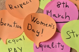 a cloud of sticky notes of different colors in the shape of speech balloons with concepts relative to the womens day written in it, such as equality respect, progress, liberation or equal pay